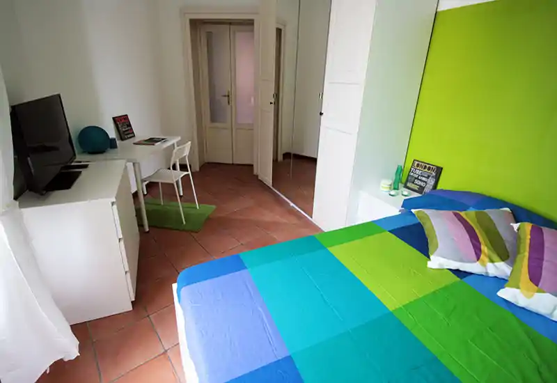 Bright, colorful bedroom with a double bed, bedside table and wardrobe with mirrored doors. Clean, modern styling and natural light make it ideal for rental listings.