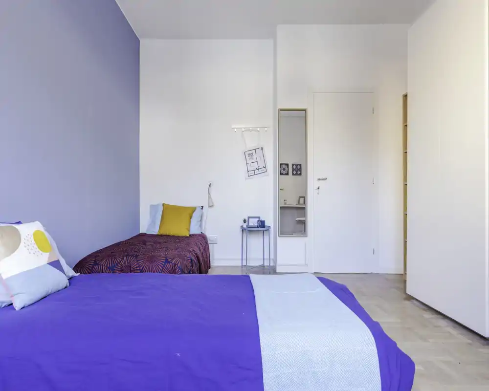 Dormitorio moderno y luminoso con dos camas, paleta azul y blanca, textiles acogedores y mesita de noche — ideal para estancias cómodas.