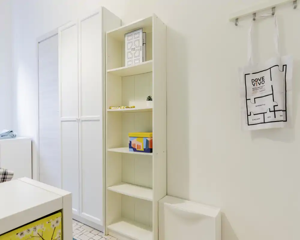 Pièce lumineuse et minimaliste avec étagères blanches et armoire — un espace rangé et polyvalent avec des rangements modernes.