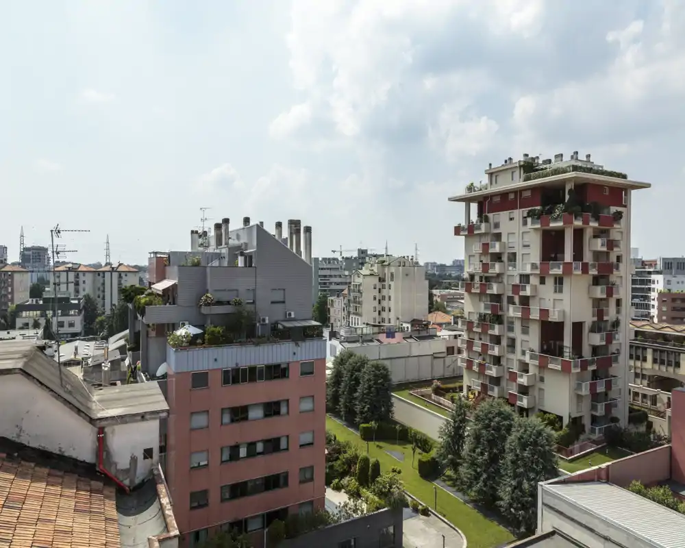 Bright urban view showing apartment buildings, terraces and a landscaped courtyard — ideal to highlight outdoor spaces and neighborhood feel.