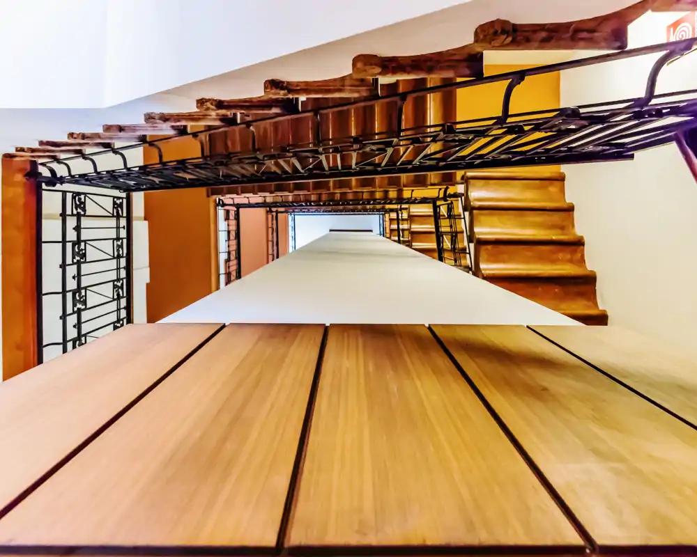 A vertical/artistic view of an interior stairwell with visible steps, metal railings and a central column; not showing a functional room for a rental listing.