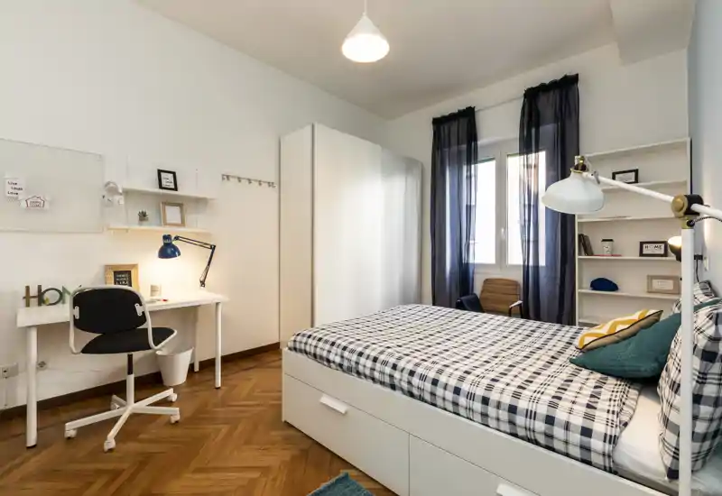 Dormitorio luminoso y bien decorado con cama doble, cojines a juego, escritorio y armario — ideal para una o dos personas.