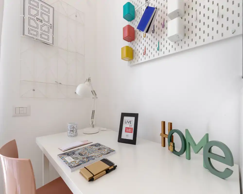 Coin bureau lumineux et minimaliste avec bureau blanc, lampe, papeterie et décorations « home » — parfait pour étudier ou télétravailler.