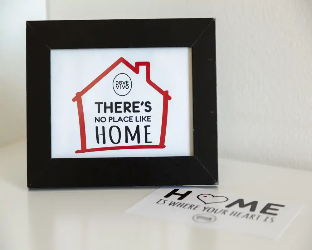 Detalle de un marco decorativo con el texto «There's no place like home» sobre una superficie clara; la imagen muestra un detalle de decoración y no permite identificar una habitación concreta.
