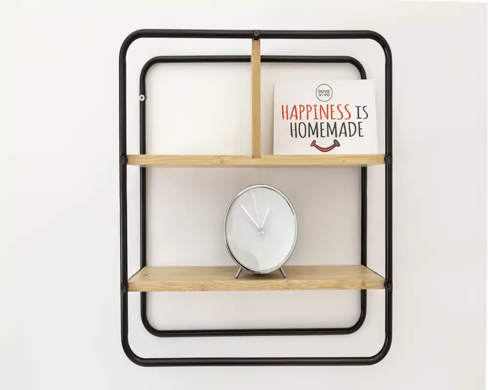 Primer plano de una estantería de pared decorativa con un reloj minimalista y un pequeño cartel que dice "Happiness is homemade" sobre una pared lisa.