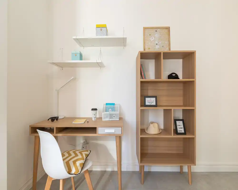 Neat study corner with a wooden desk, chair and open shelving; bright, minimal and well organized — ideal for remote work or reading.