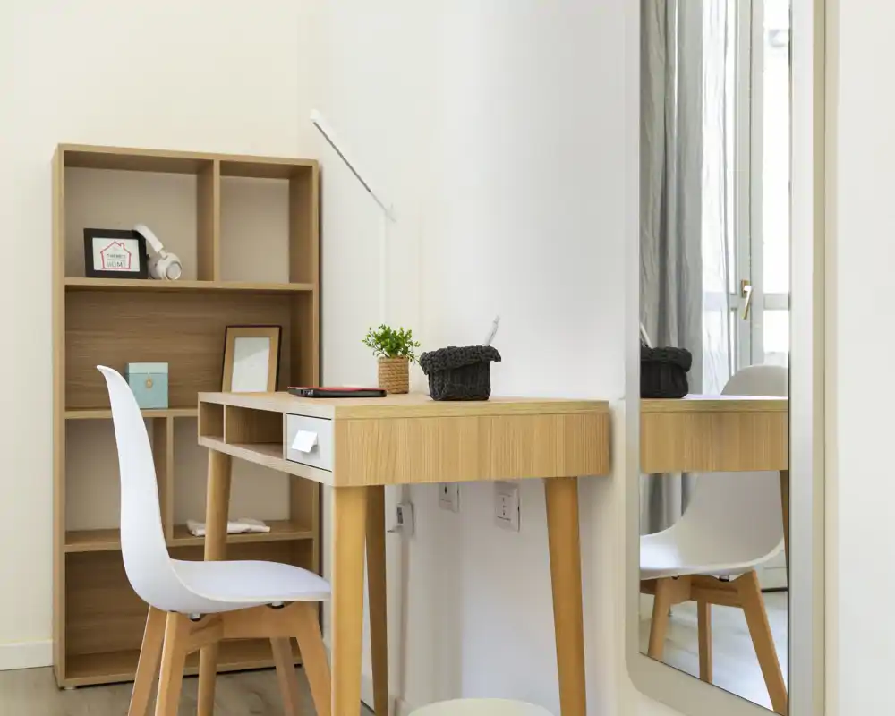Espace de travail lumineux et minimaliste avec bureau en bois, chaise blanche et étagère — parfait pour un bureau à domicile ou un coin étude lumineux.