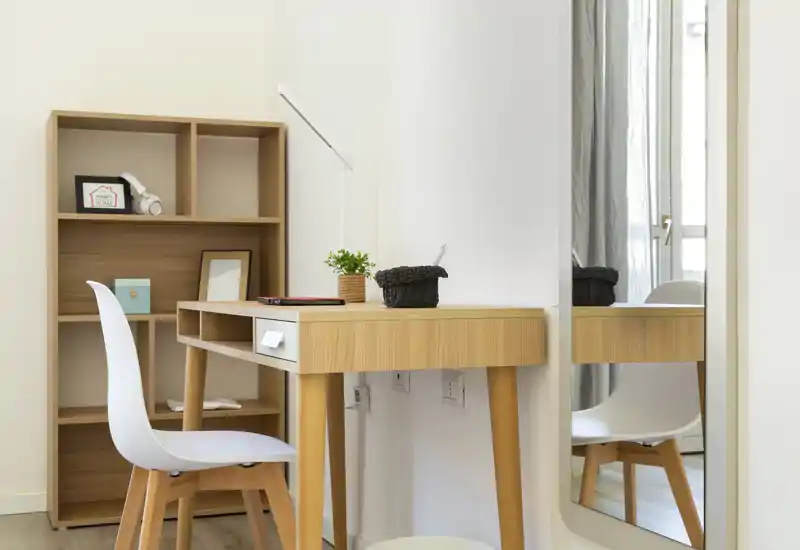 Espace de travail lumineux et minimaliste avec bureau en bois, chaise blanche et étagère — parfait pour un bureau à domicile ou un coin étude lumineux.