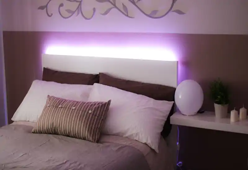 Camera da letto confortevole e curata, con letto ben visibile, biancheria morbida e illuminazione d'accento che crea un'atmosfera calda.