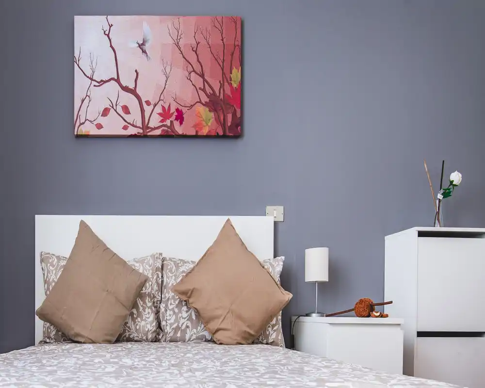 Camera da letto luminosa e arredata con biancheria stampata, due cuscini decorativi e comodini coordinati — un ambiente moderno e accogliente perfetto per un annuncio.