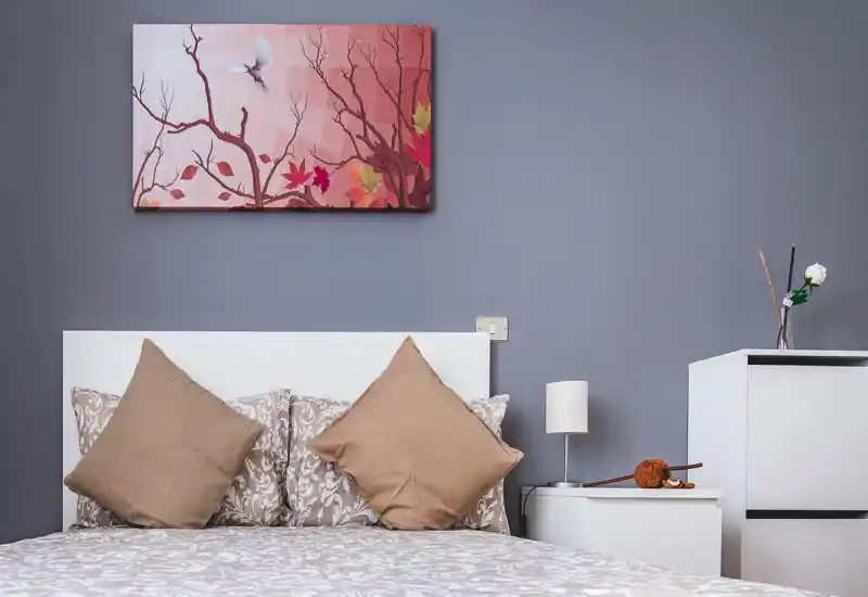 Dormitorio luminoso y decorado con ropa de cama estampada, dos cojines decorativos y mesitas coordinadas — un espacio moderno y acogedor perfecto para un anuncio.