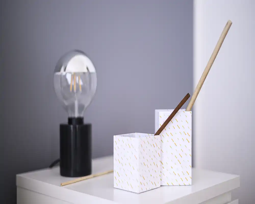 Unable to determine a specific room: close-up of a bedside surface with decorative boxes and a lamp; no clear full furniture or room context is visible.