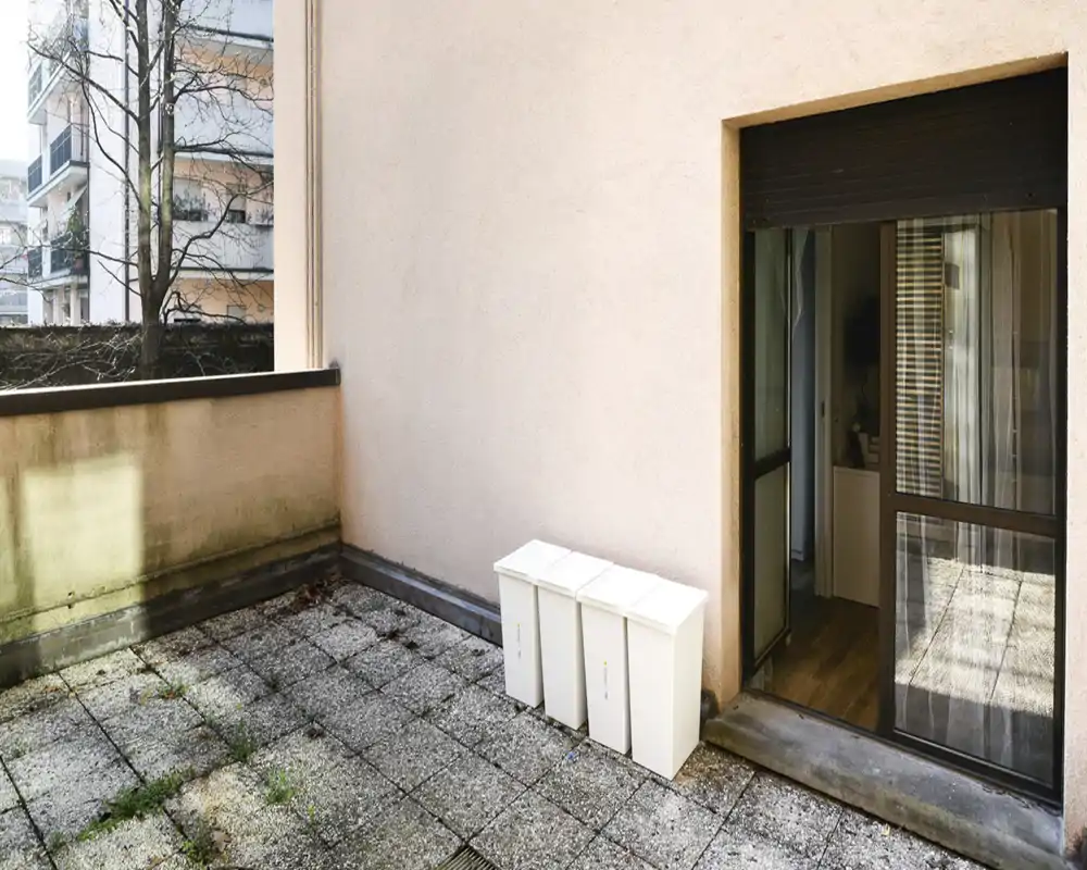 Terraza privada soleada con suelo de baldosas y acceso directo desde el interior mediante puerta corredera — ideal para el desayuno al aire libre o un pequeño rincón de descanso.