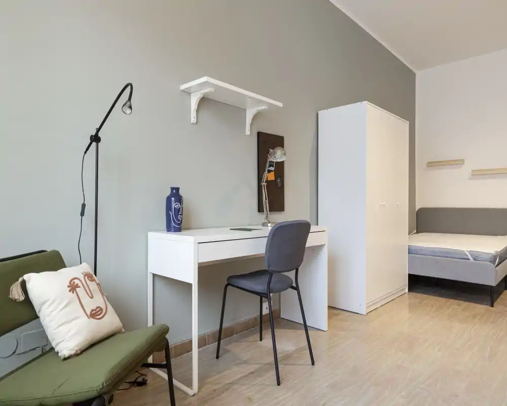 Bright, well-styled bedroom corner with a single bed, wardrobe and a study desk — ideal for a student or solo tenant.