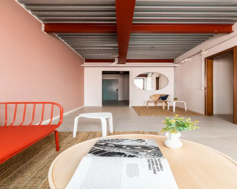 Ampio soggiorno moderno con arredi minimalisti, tappeti in fibra naturale e accenti caldi; ambiente luminoso e arioso perfetto per rilassarsi o ospitare.