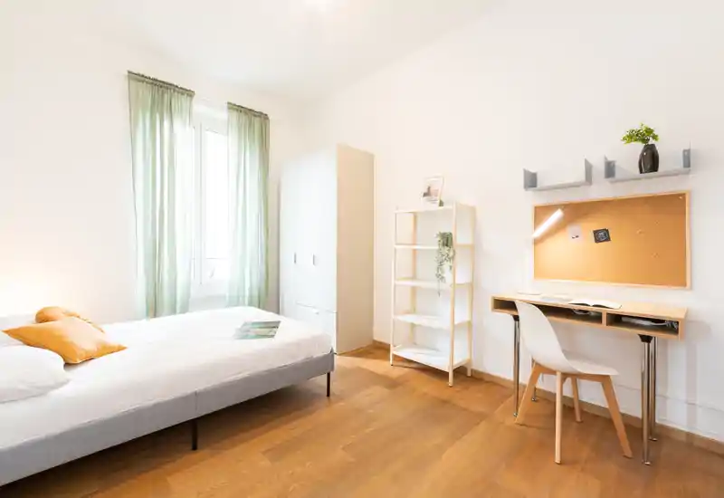 Camera da letto luminosa e ben arredata con letto comodo, angolo studio e armadio — ideale per studenti o viaggiatori singoli.