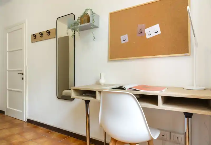 Coin bureau lumineux et minimaliste avec tableau en liège, lampe et miroir — idéal pour un espace de télétravail ou d'étude.