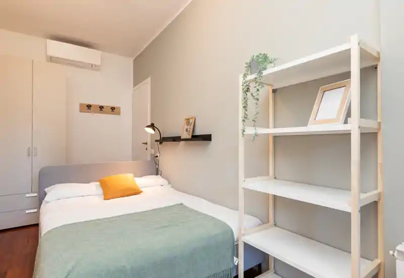 Cozy, well-staged bedroom with a double bed, soft textiles and a neutral color palette—bright and inviting for guests.