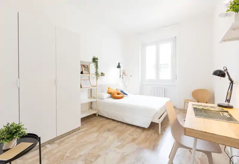 Camera da letto luminosa e minimal con letto comodo, scrivania e armadio — stile scandinavo pulito con tocchi caldi.