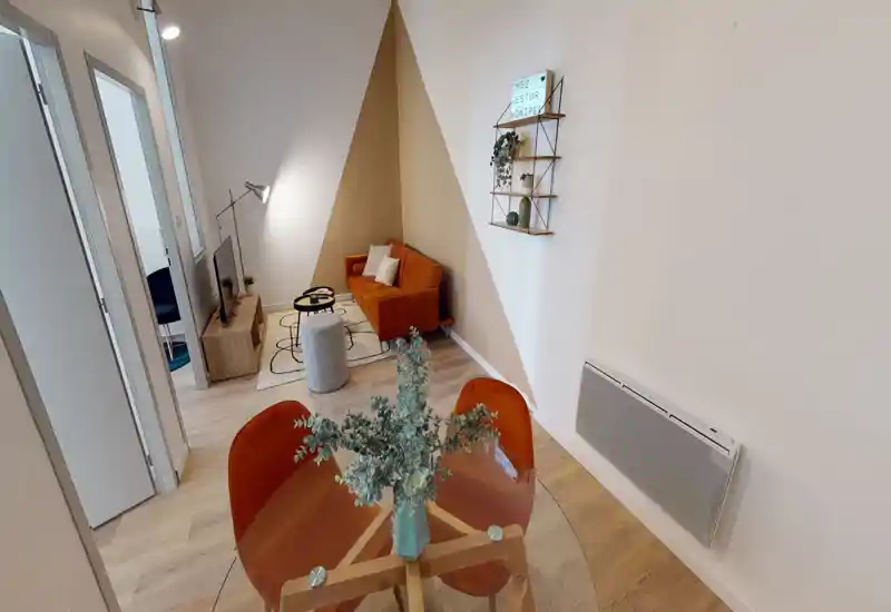 Coin salon clair et élégant avec un canapé couleur rouille, lampe sur pied et meuble TV ; idéal pour se détendre ou recevoir.