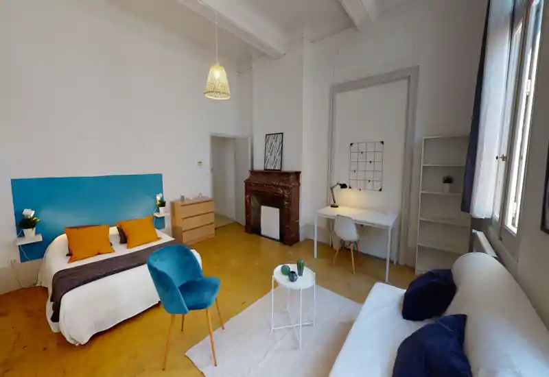 Camera da letto spaziosa e luminosa con letto matrimoniale comodo, testiera colorata e cuscini decorativi; scrivania e zona salotto ideali anche per lavorare da remoto.