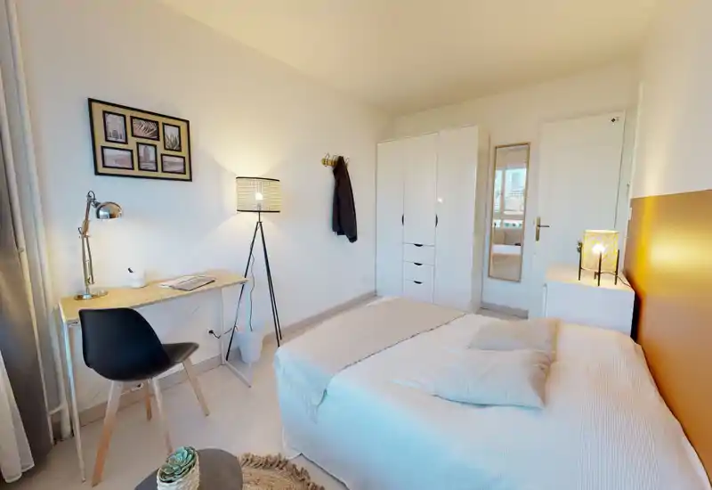 Chambre lumineuse et bien aménagée avec un lit double confortable, table de chevet et armoire; un petit bureau près de la fenêtre idéal pour télétravailler.