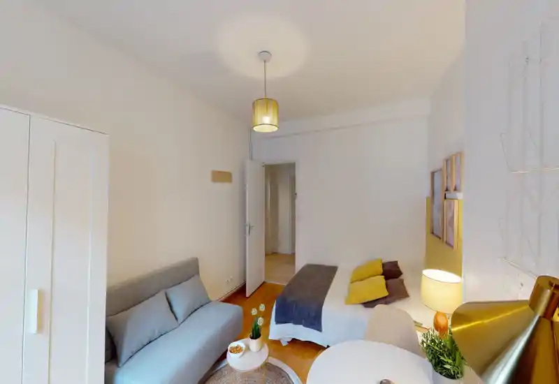 Bright, well-styled bedroom with a double bed, cozy textiles and a small seating area. Warm lighting and tasteful decor create a welcoming atmosphere ideal for short-term rentals.