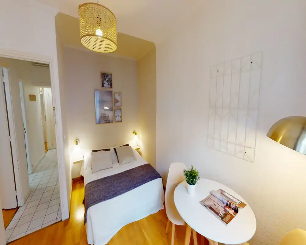 Camera da letto luminosa e ben arredata con letto matrimoniale, lampade da comodino e un piccolo tavolo: accogliente e ideale per soggiorni brevi.