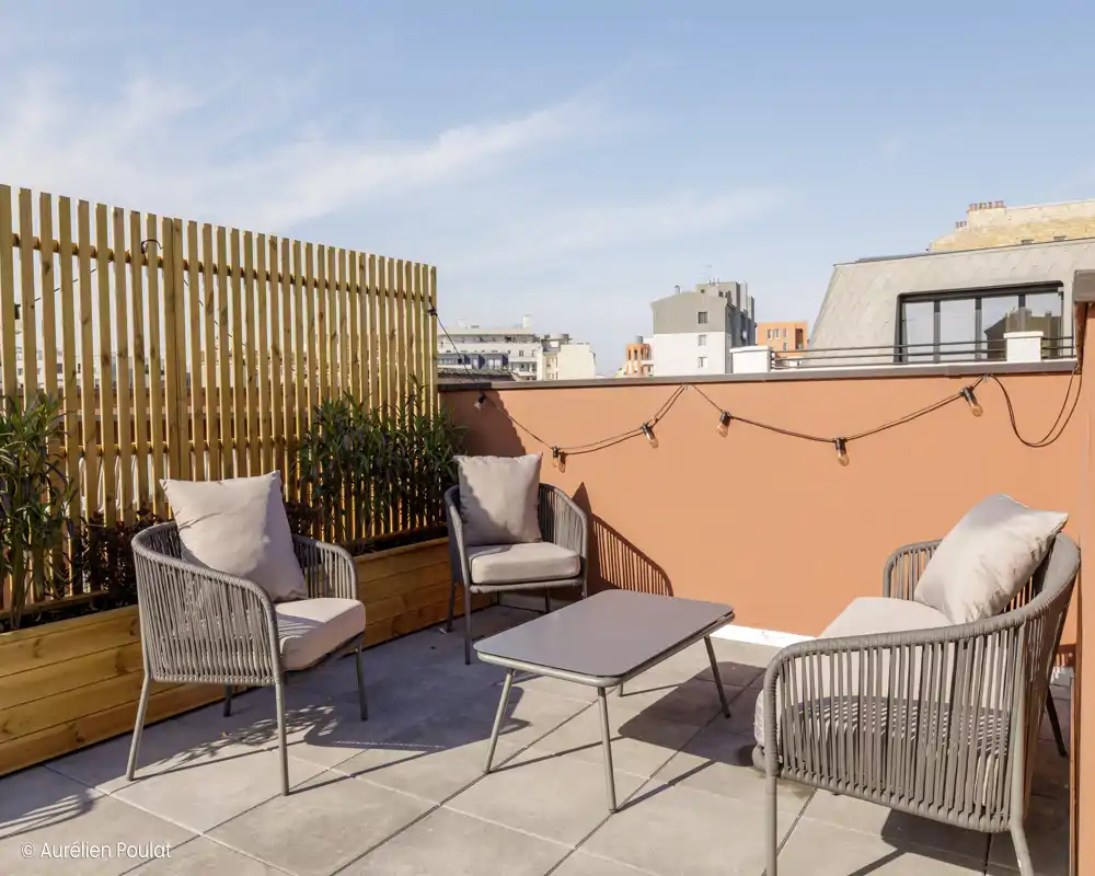 Terrazza esterna con lettini e muretti bassi; ideale per prendere il sole o rilassarsi all'aperto. L'immagine mostra arredi e cielo aperto, sebbene presenti artefatti digitali.