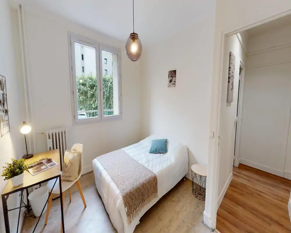 Camera da letto luminosa con letto ben rifatto, tessili morbidi e una finestra che fornisce luce naturale. L'immagine presenta artefatti digitali ma la stanza sembra accogliente e ben illuminata.