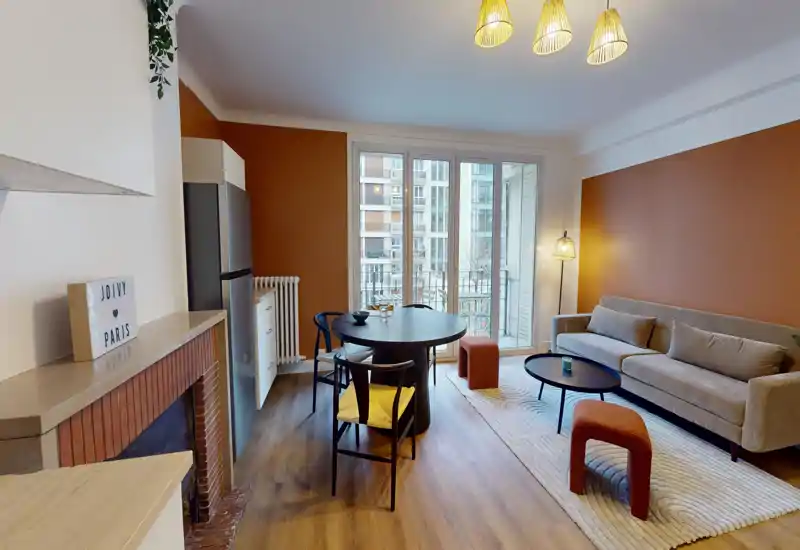 Bright, stylish living room with a comfortable sofa, coffee table, dining table and large windows that bring in natural light — ideal for relaxing or entertaining.