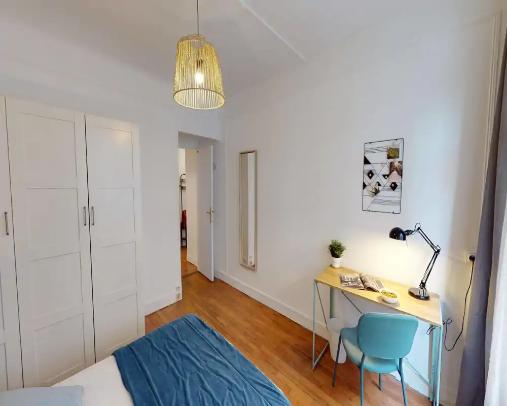 Dormitorio luminoso y bien arreglado con cama visible, armario y un pequeño escritorio junto a la ventana—ideal para una estancia cómoda.