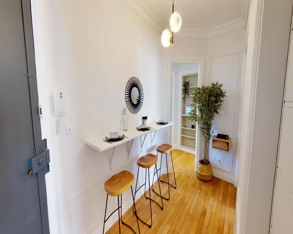 Bright living area with modern seating and decorative plants. The image is heavily distorted but suggests a cozy lounge space with light walls and natural accents.