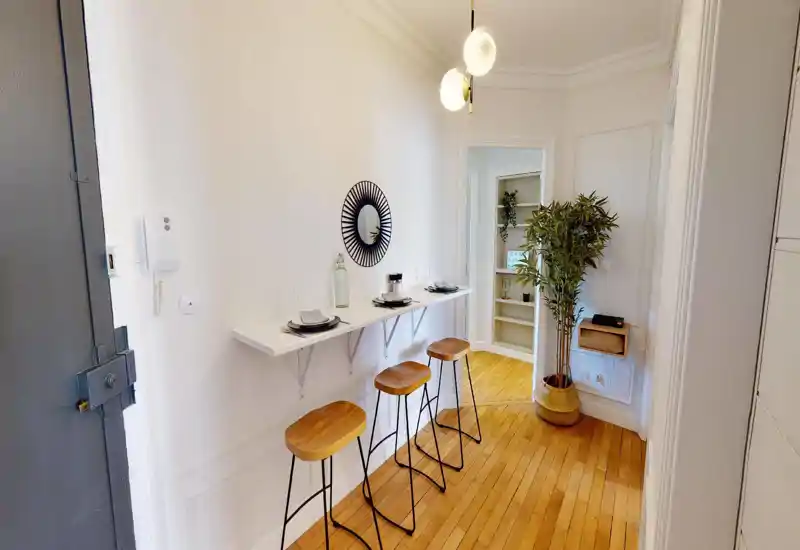 Bright living area with modern seating and decorative plants. The image is heavily distorted but suggests a cozy lounge space with light walls and natural accents.