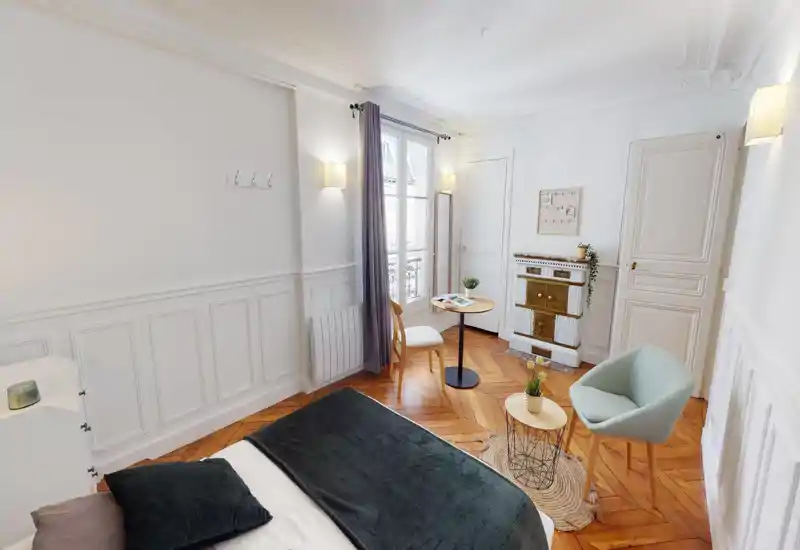Bright attic-style bedroom with sloped ceilings and a visible bed area framed by light walls; image is corrupted but the sleeping area and bedside furnishings are perceptible.