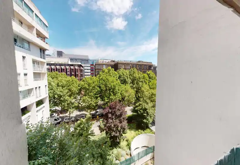 Outdoor view with trees and sky; image heavily glitched but suggests a balcony or street-level greenery.