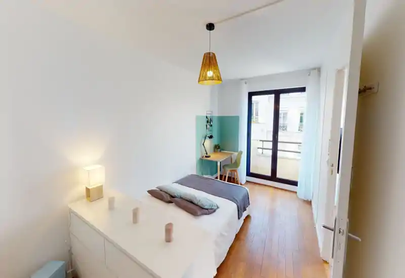 Chambre moderne et lumineuse avec un lit double confortable, des textiles doux et un petit bureau près de la fenêtre. Grandes portes-fenêtres pour une belle luminosité et parquet chaleureux.