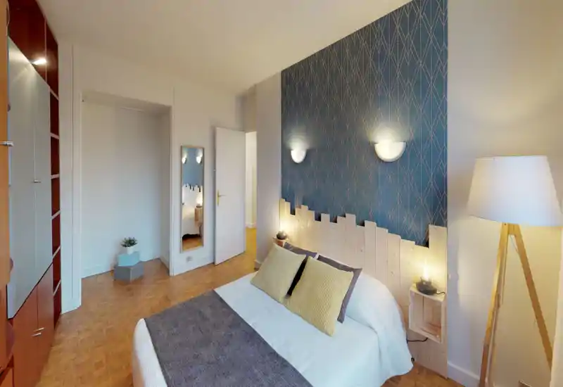 Camera da letto luminosa e di design con letto matrimoniale, carta da parati elegante, luci da comodino e testiera in legno che creano un'atmosfera accogliente.