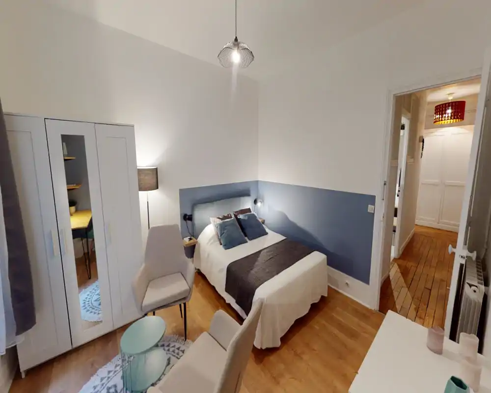 Bright, well-styled bedroom with a double bed, upholstered headboard and coordinated cushions; wardrobe and seating area create a comfortable, ready-to-rent space.