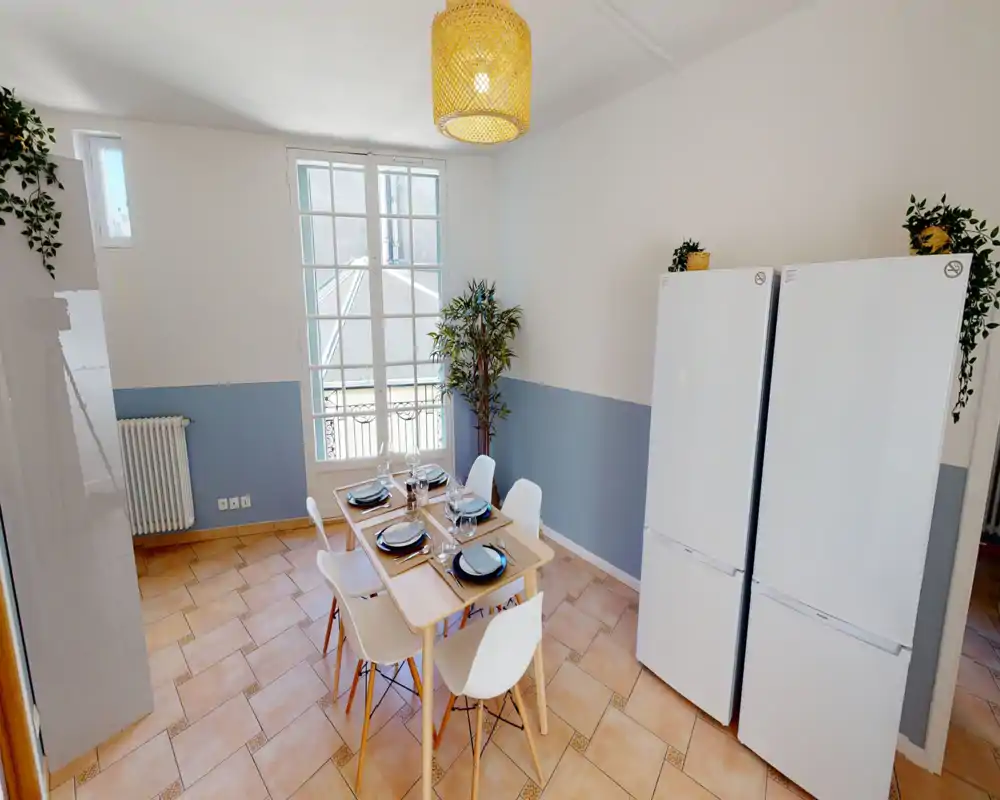 Bright, styled dining area with a set table for six, large window providing natural light, and modern white chairs — ideal for shared meals.