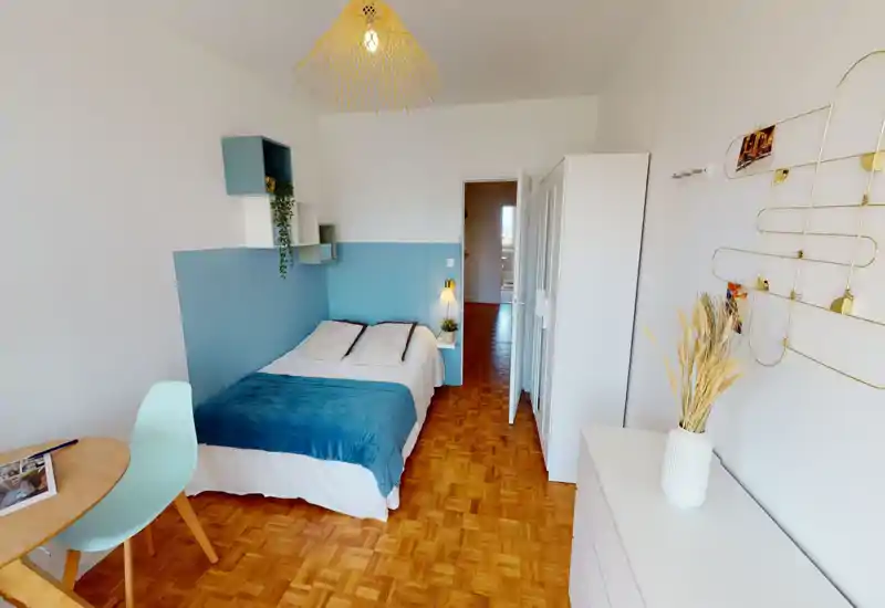Dormitorio luminoso y ordenado con cama doble en ropa de cama blanca y manta turquesa, estanterías minimalistas y luz suave — perfecto para anuncios que destaquen una habitación acogedora.