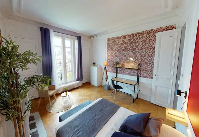 Camera da letto luminosa e di design con grande finestra, parete decorativa e un comodo letto matrimoniale in primo piano — perfetta per rilassarsi o lavorare alla scrivania.