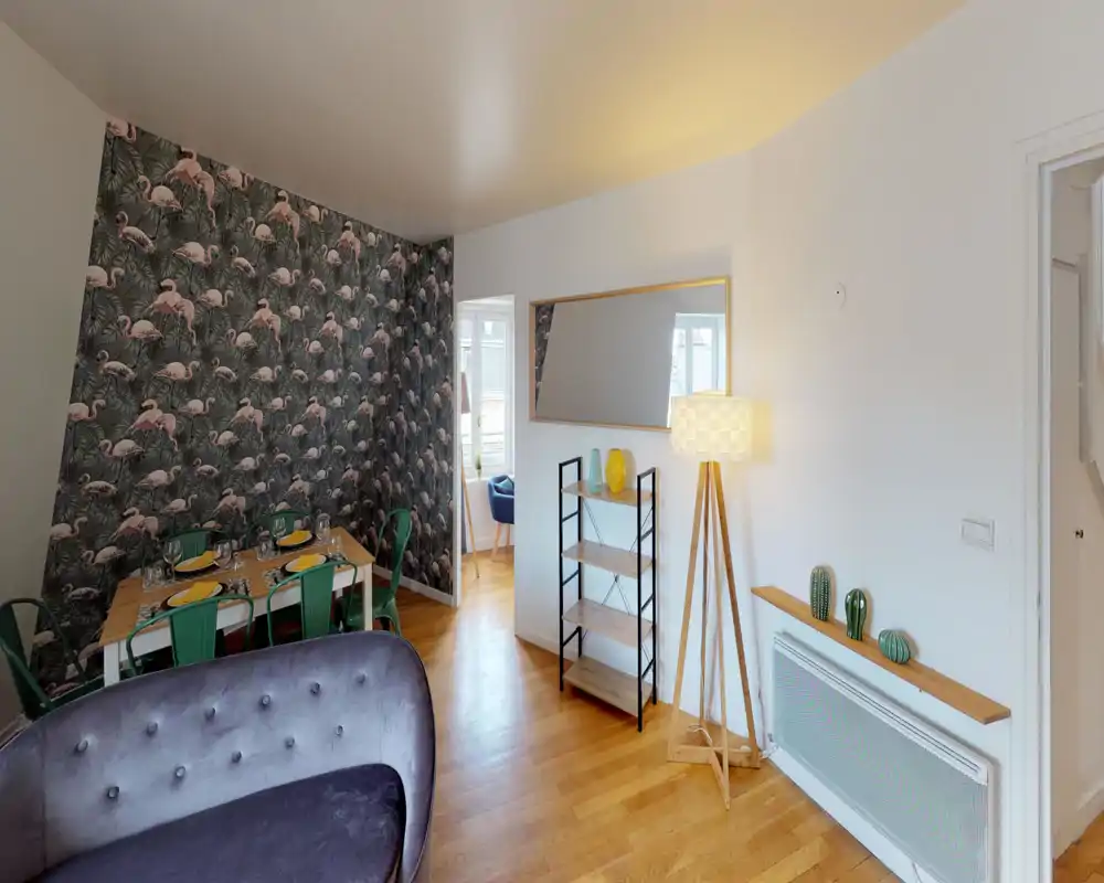 Salon spacieux et élégant avec un mur d'accent à motif, canapé en velours confortable, table à manger dressée et lampe sur pied chaleureuse — lumineux et accueillant pour recevoir.