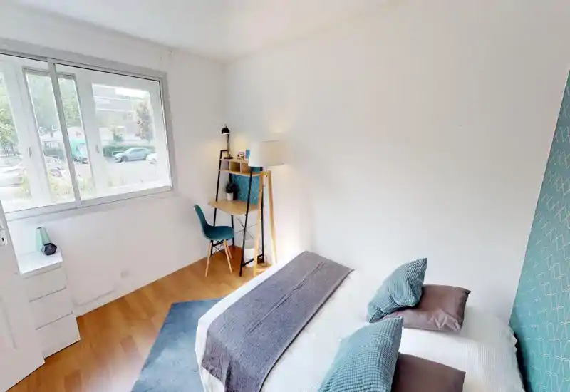 Bright attic bedroom with a visible bed covered in textured bedding and pillows; the image is heavily artifacted but shows a cozy sleeping area beneath sloped ceilings.