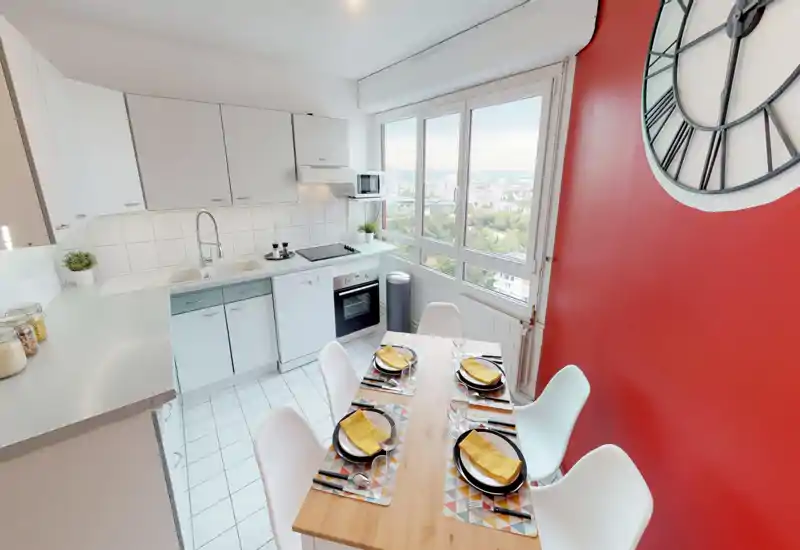 Bright, modern kitchen with a dining table set for four. Large window provides panoramic city views while a red accent wall and coordinated place settings add character.