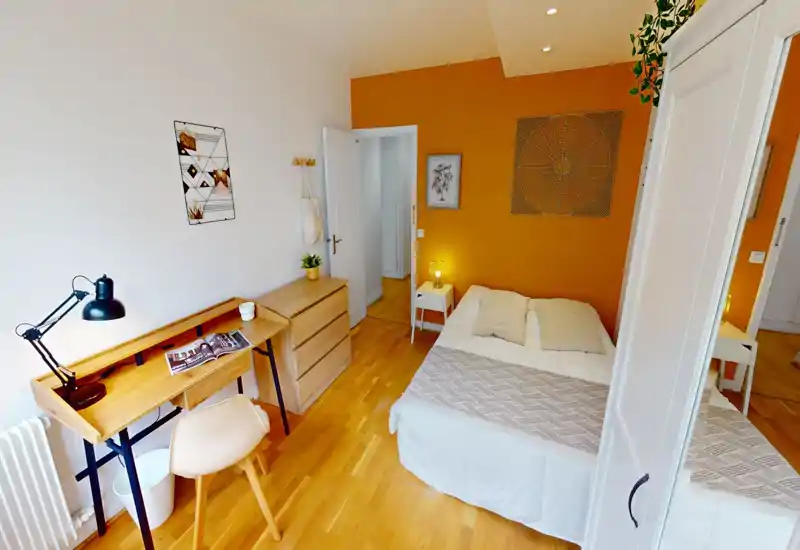 Sunny, well-styled bedroom with a double bed, wooden flooring and a small work desk. Warm accent wall, bedside table with lamp and tidy storage make this room comfortable and functional.