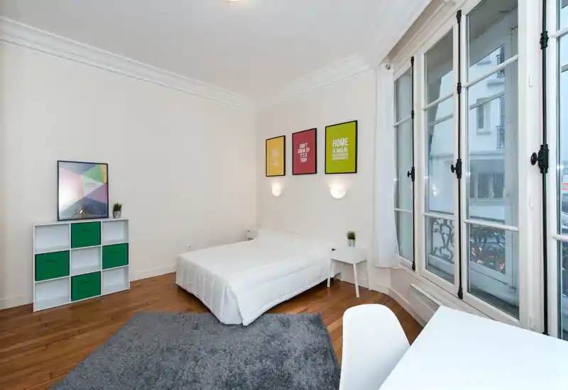 Camera da letto moderna e luminosa con letto matrimoniale, comodini, tappeto morbido e ampie finestre che garantiscono molta luce naturale.