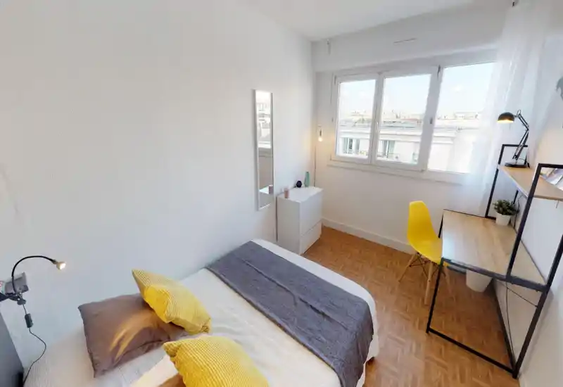 Bright, compact bedroom with a neatly made double bed, soft pillows and a cozy throw. A desk by the window and minimalist storage make it ideal for a single occupant or short stays.