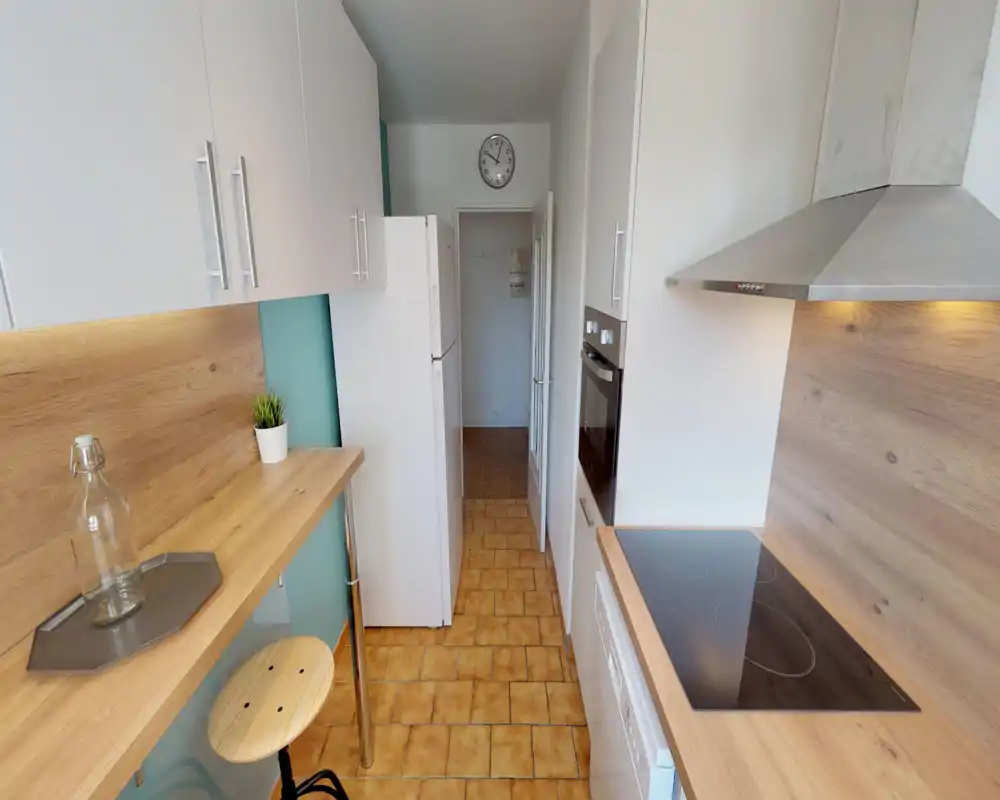 Compact modern galley kitchen with wooden countertops, glass-ceramic hob, built-in oven and fridge. Warm wood finishes and under-cabinet lighting create a tidy, efficient cooking space.