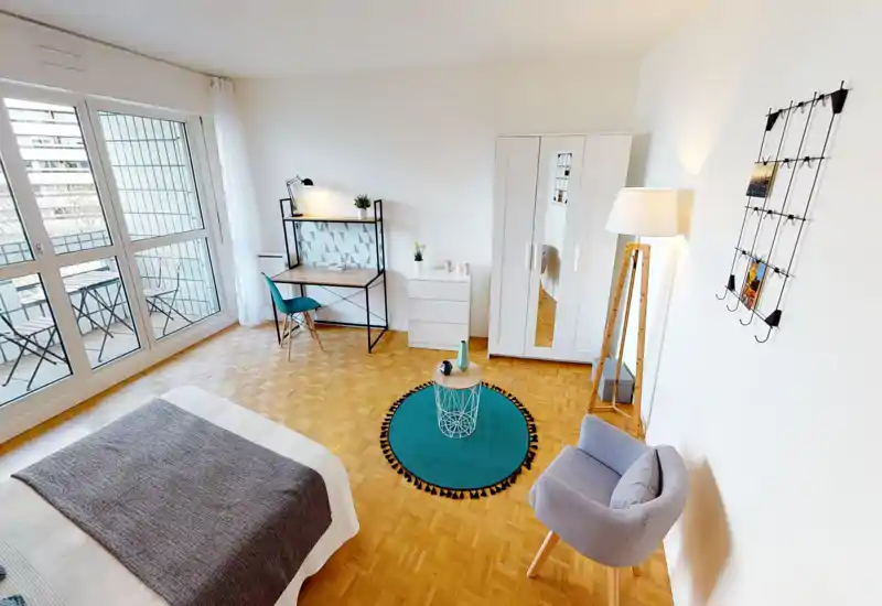 Camera da letto moderna e luminosa con grandi finestre, letto ben rifatto, area studio e accesso al balcone — allestimento curato e illuminazione ideale per annunci.